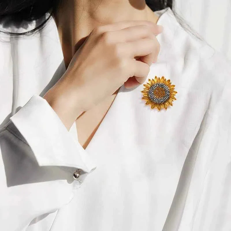 Sunflower crystal lapel pin on a white blouse, gold-tone petals with amber-toned center