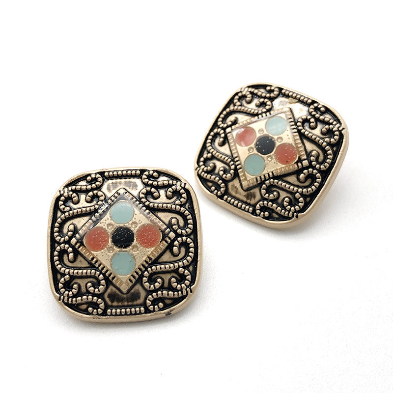 Metal shank button with multicolor gem in a diamond frame and ornate black border