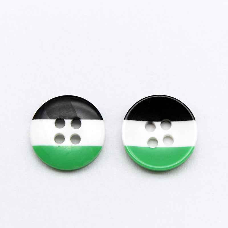 Round resin button with black and white top stripe, plus green bottom; four holes.