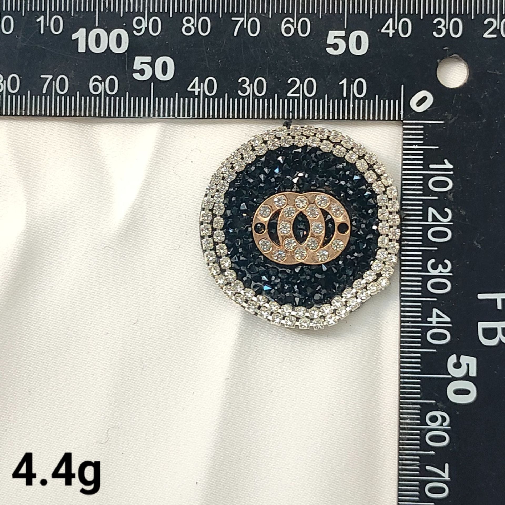 Black round bee logo patch with gold center and silver crystal border