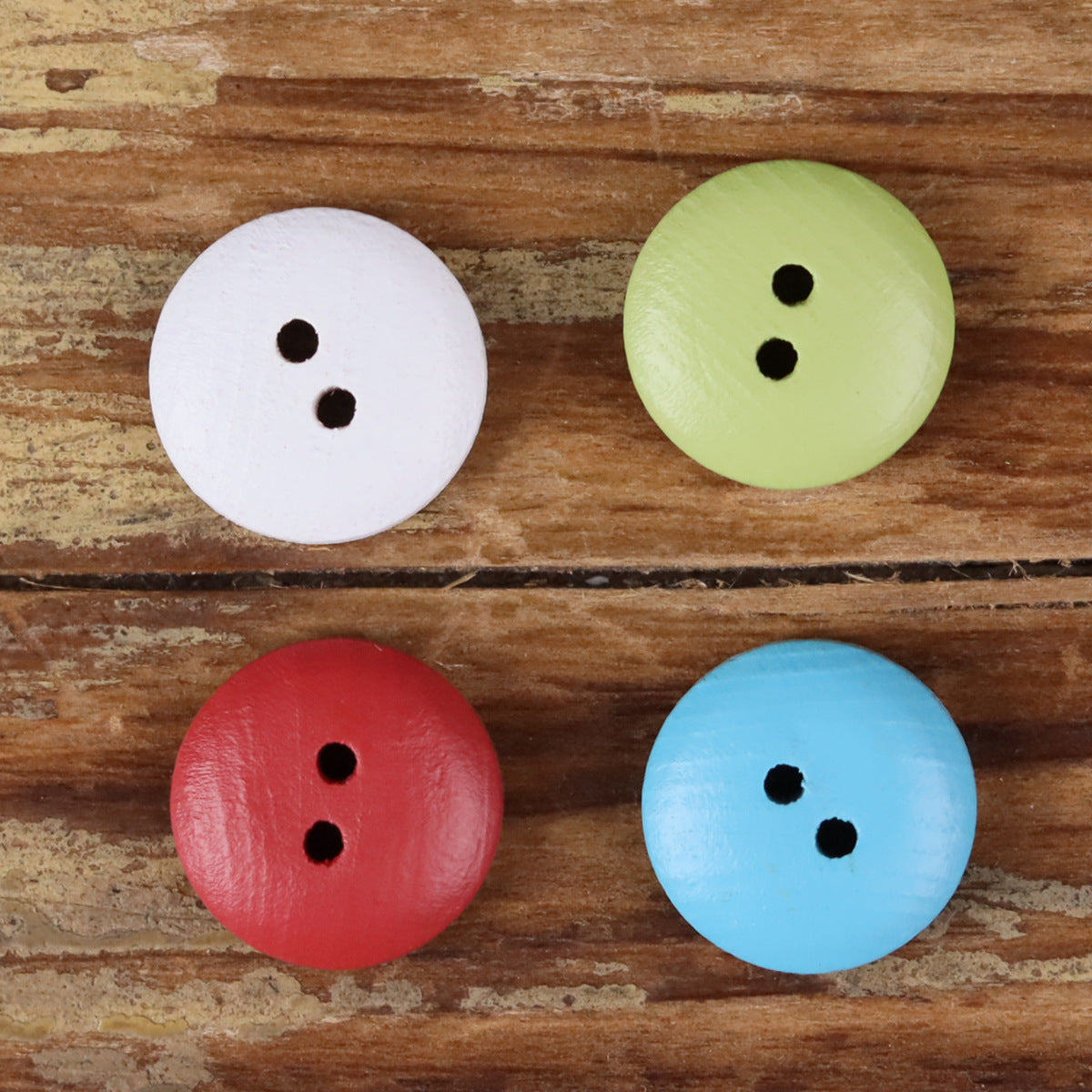 Round 2-hole wood buttons with painted floral designs in white, light green, red, and blue.