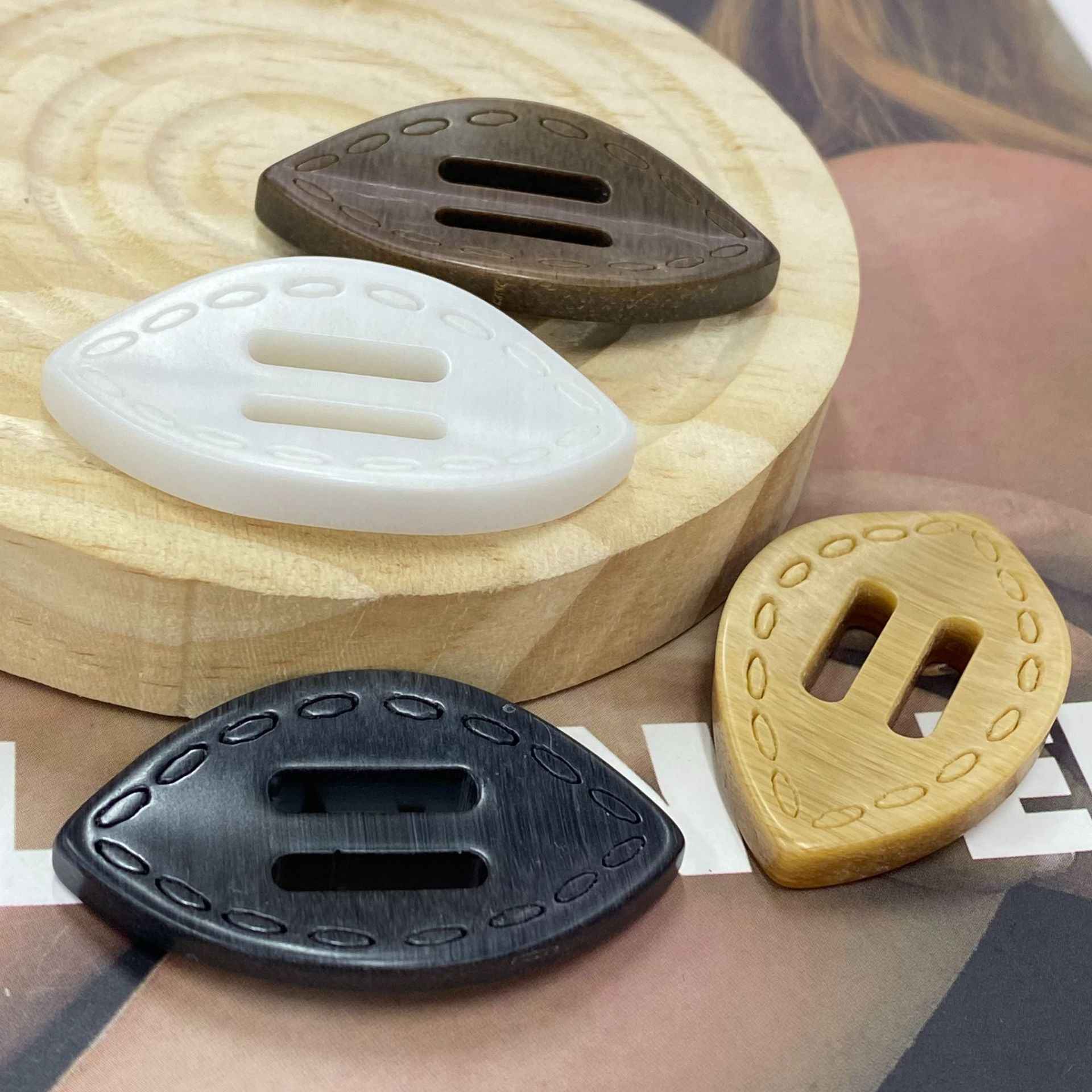 Oval 2-hole resin buckle buttons in white, dark gray, and light gold tones