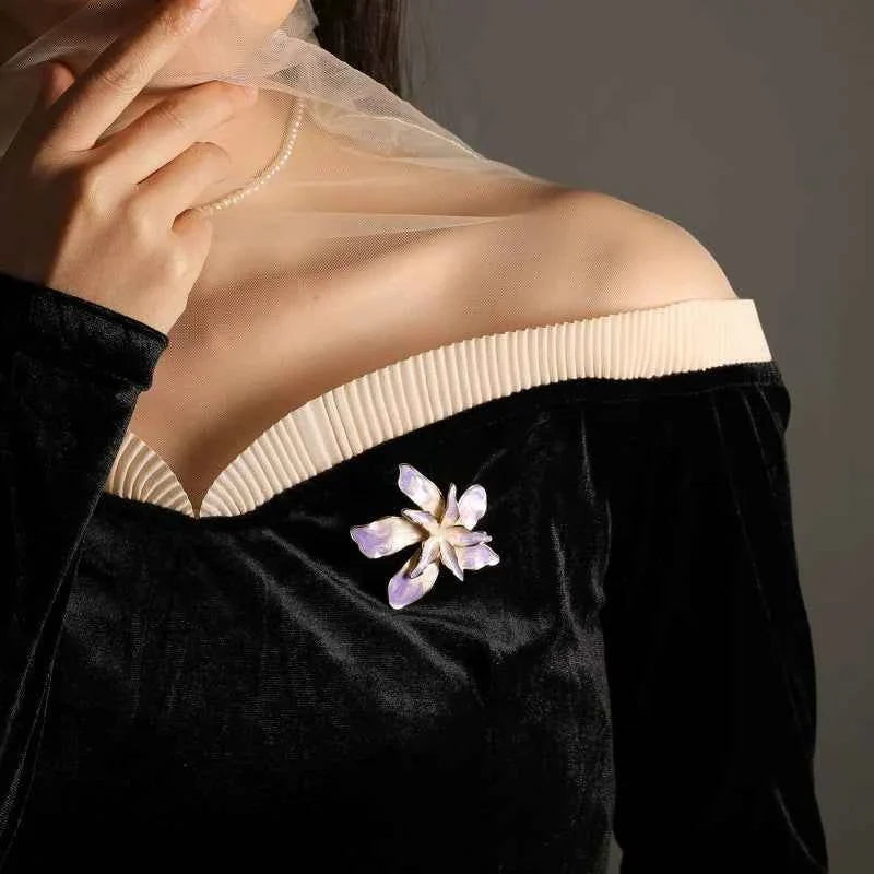 Orchid brooch pin in lilac with gold border, pinned on black velvet fabric