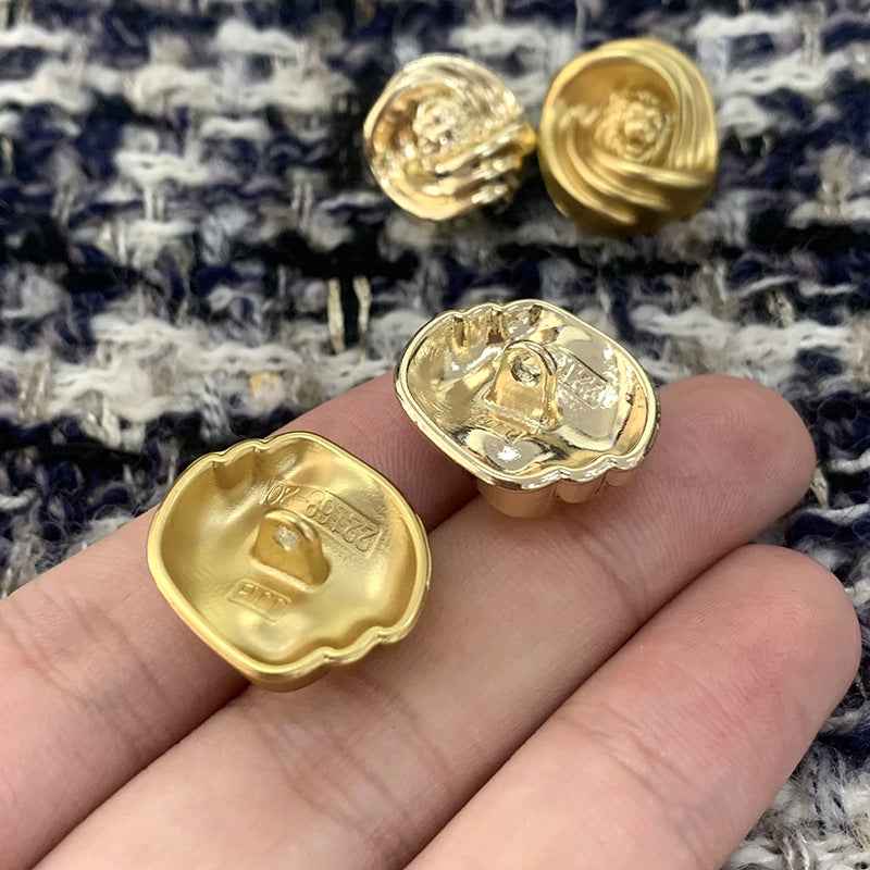 Goldfarbene Metallknöpfe mit Löwenkopf-Design und Knopfösen, vier Knöpfe im Detail