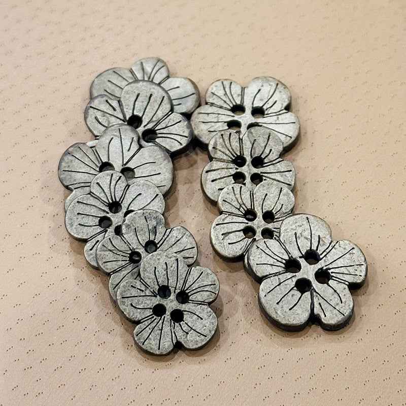 Plum blossom shoe buttons in dark silver-gray with outlined floral perforations