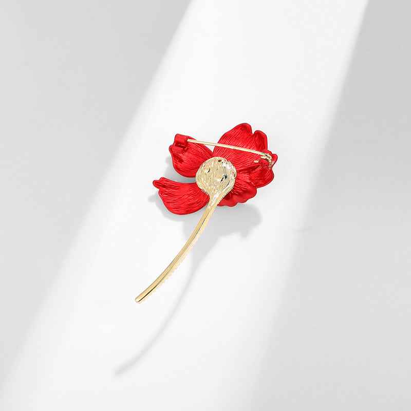 Rote Hibiskus-Brooch mit sichtbarer Nadel und kreisförmigem, goldfarbenem Blütenkern