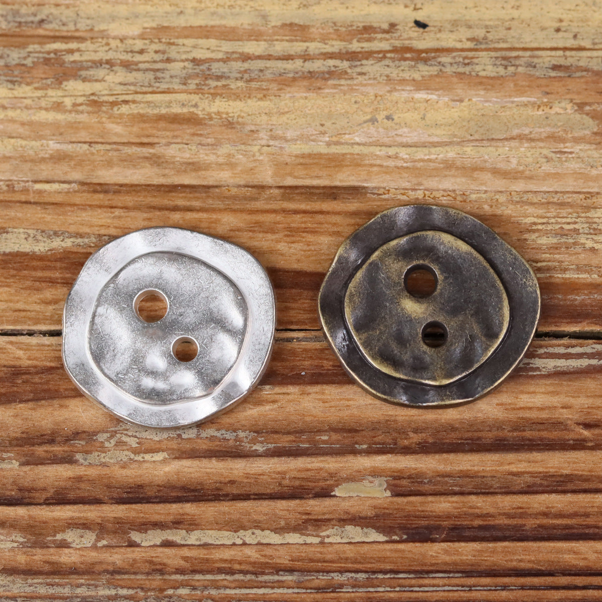 Irregular metal 2-hole buttons, silver and bronze finishes, round face with two holes.