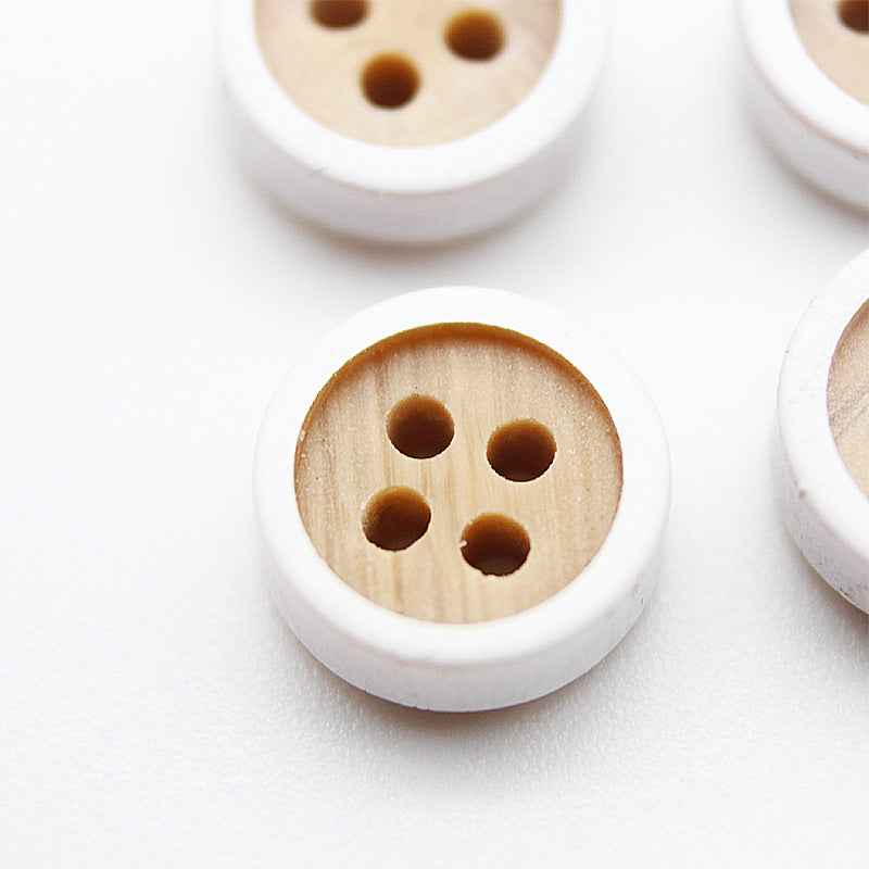 Close-up round 4-hole button, wood-grain resin face, warm tan with brown holes