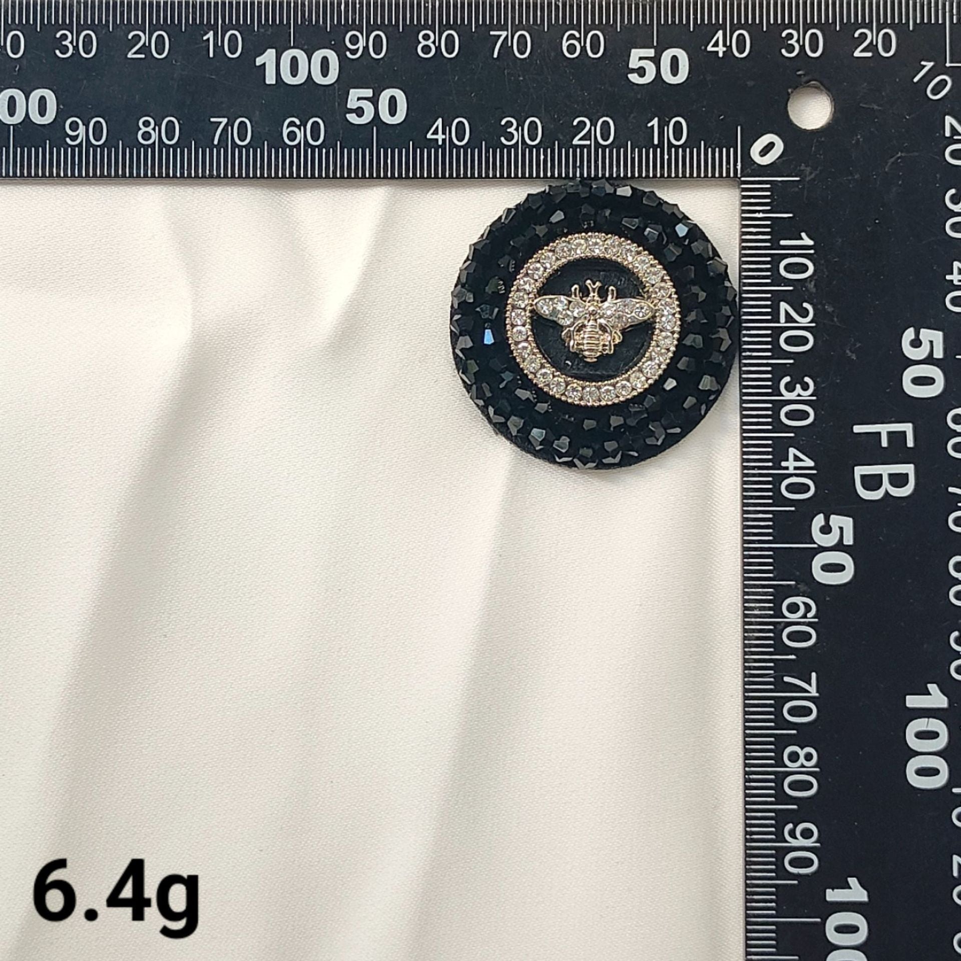 Black round crystal bee patch with gold center and decorative dark border