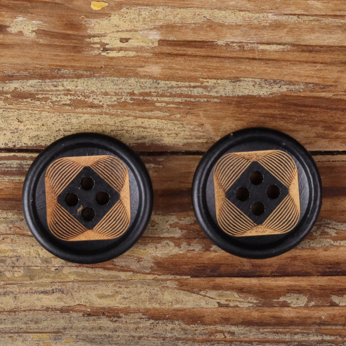 Pair of round 4-hole buttons with striped tan wood faces and black rims