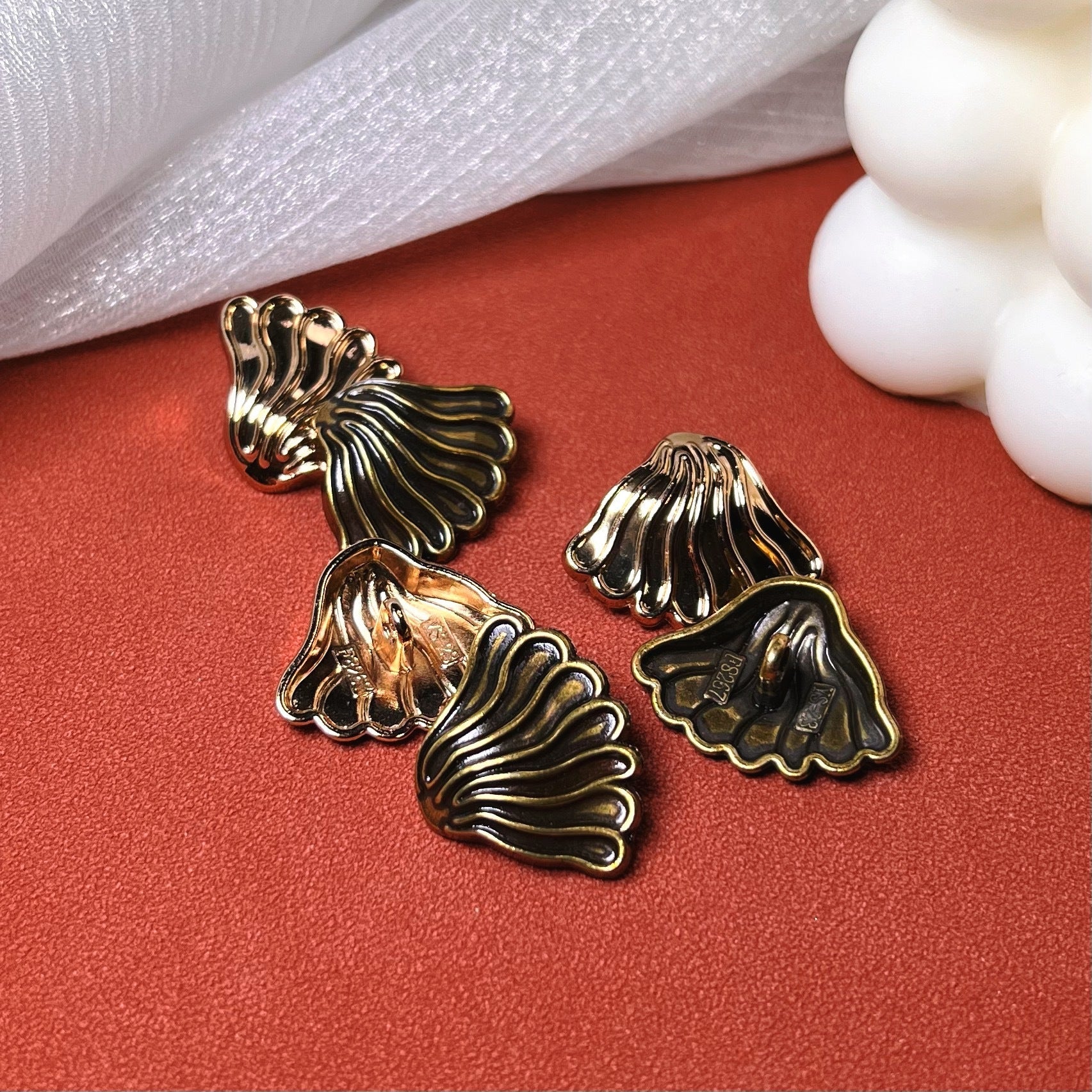 Gold-tone fan coat buttons with metal shank, textured ridges on scalloped face
