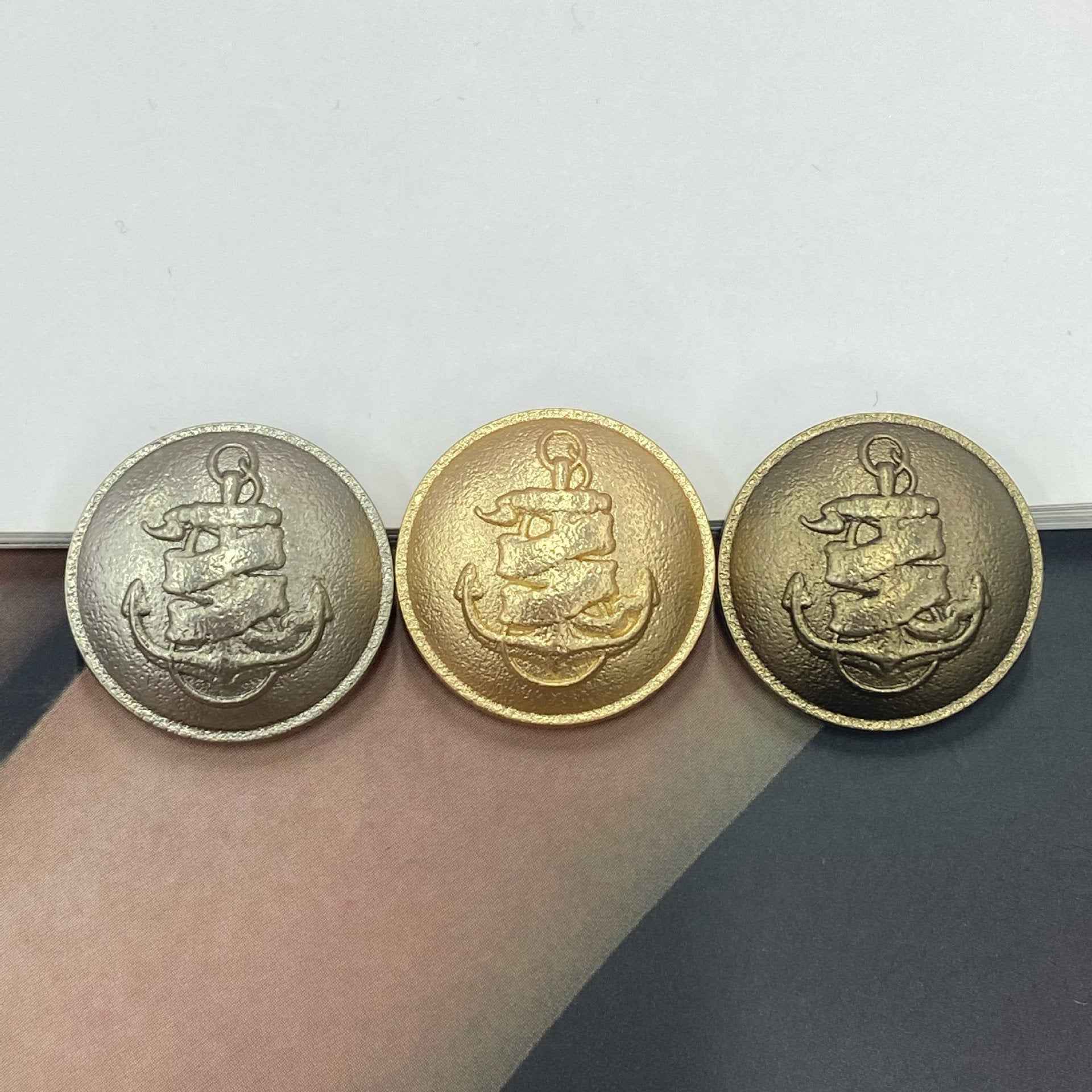 Metallknöpfe mit Anker-Relief in Nickel und Gold, 3 Stück nebeneinander