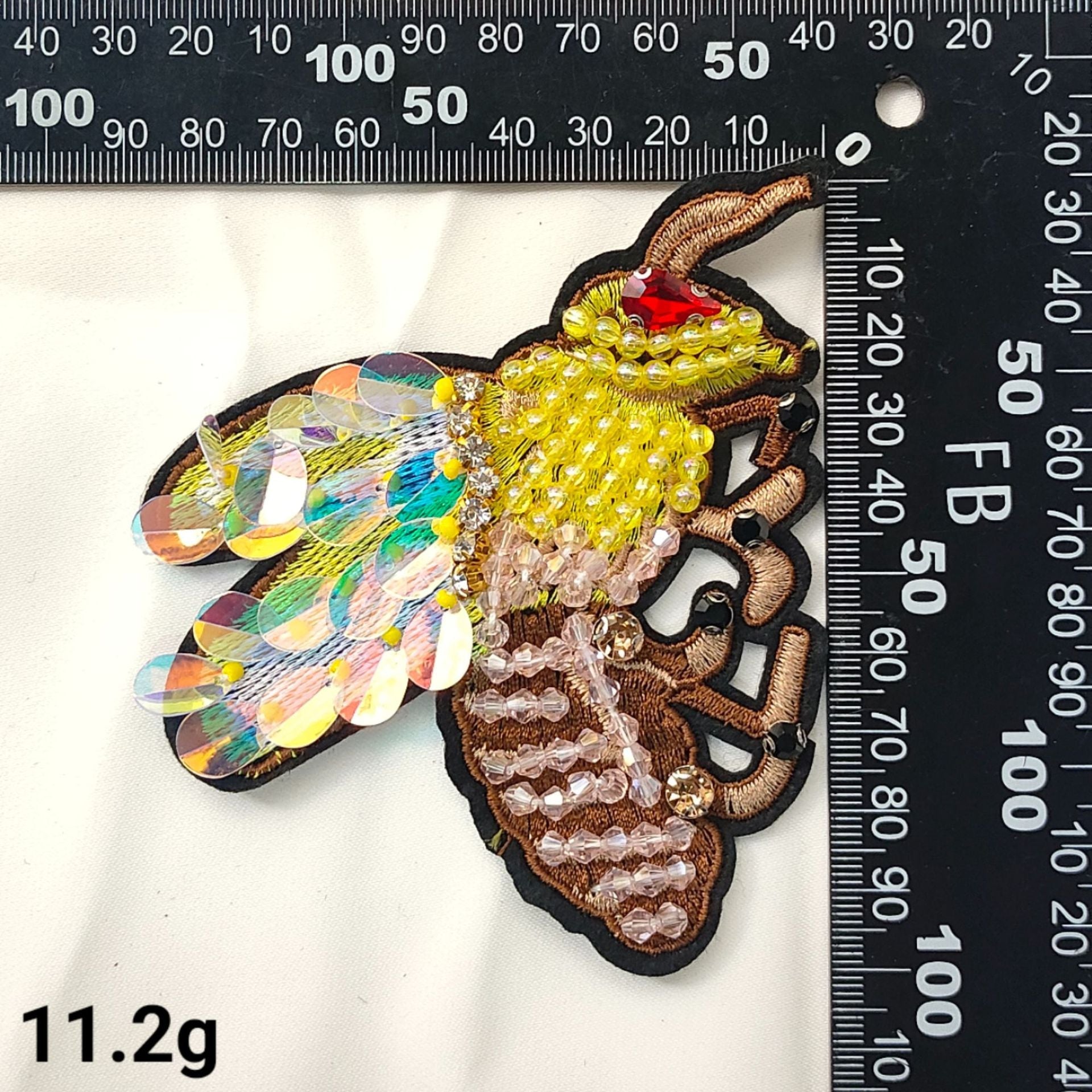 Butterfly patch with gold bead body and multicolor rhinestone wings on dark backing