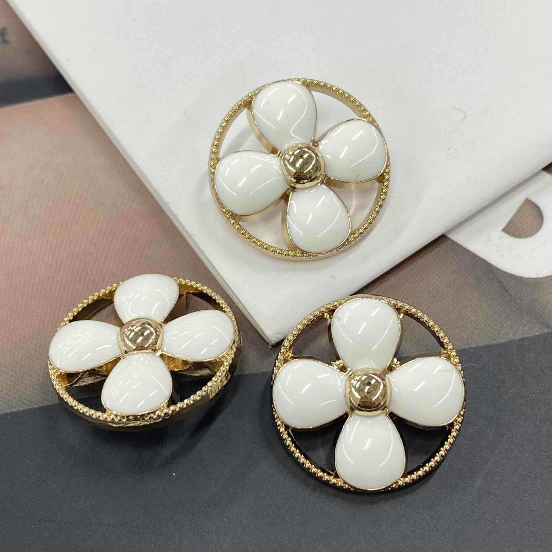 Round clover shank buttons in white, gold-tone rim and 5 petal flower center