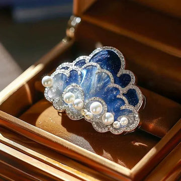 Blue cloud brooch pin with faux pearls and silver rhinestone edging.