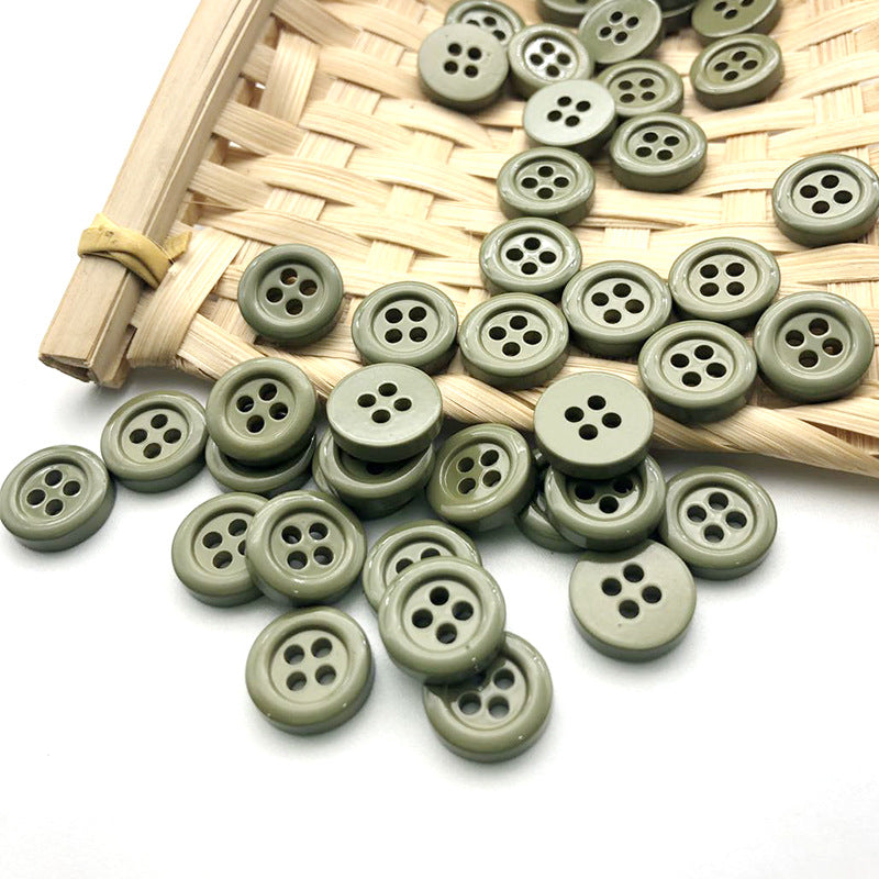 Olive green and white 11.5mm round four-hole buttons in a small basket.