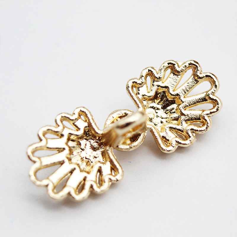 Close-up gold butterfly metal pearl buttons with white pearl centers