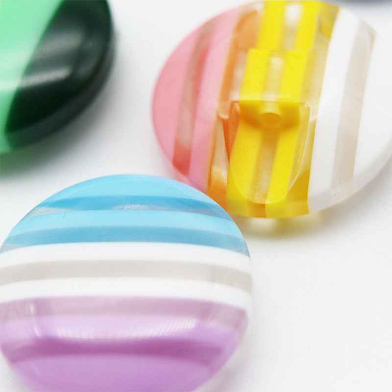 Colorful striped resin button with pastel vertical stripes, translucent top layer