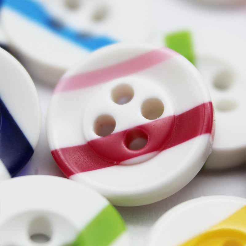 White round button with four holes and red stripe, angled close-up