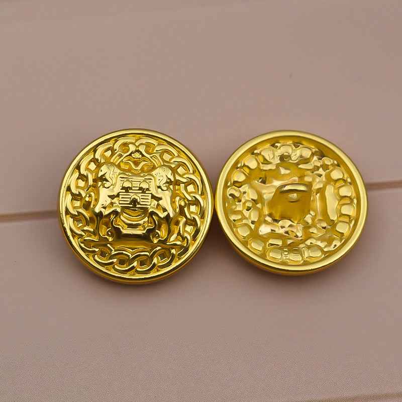 Set of two gold tone lion crest buttons with raised ornate pattern, metal shank