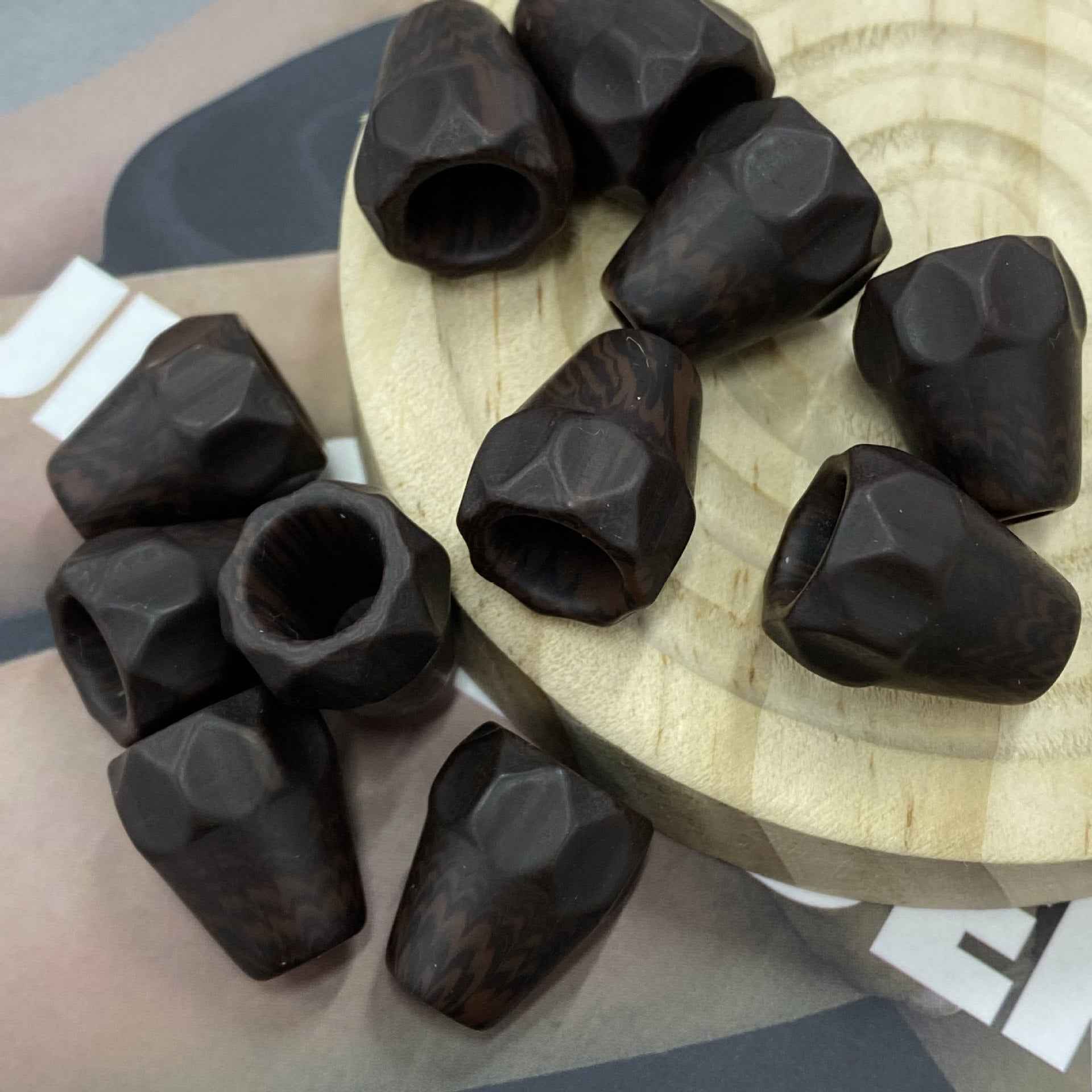 Black resin single-hole cord end stoppers, assorted pieces in a pile