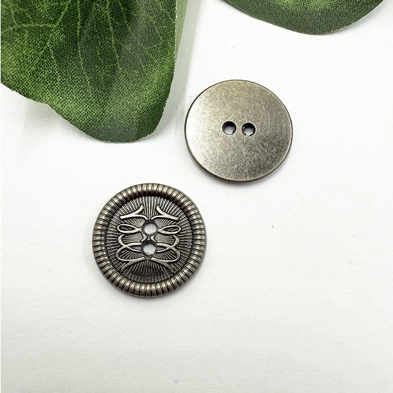 Two-hole metal button with etched floral filigree, silver tone; flat back shown