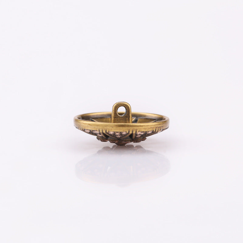 Metal shank button with hollow star crystal top; antique gold tone, side view.