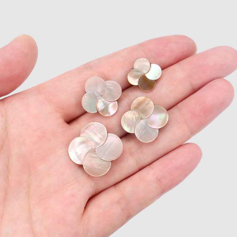 Iridescent shell butterfly buttons held in hand, pearly white tone