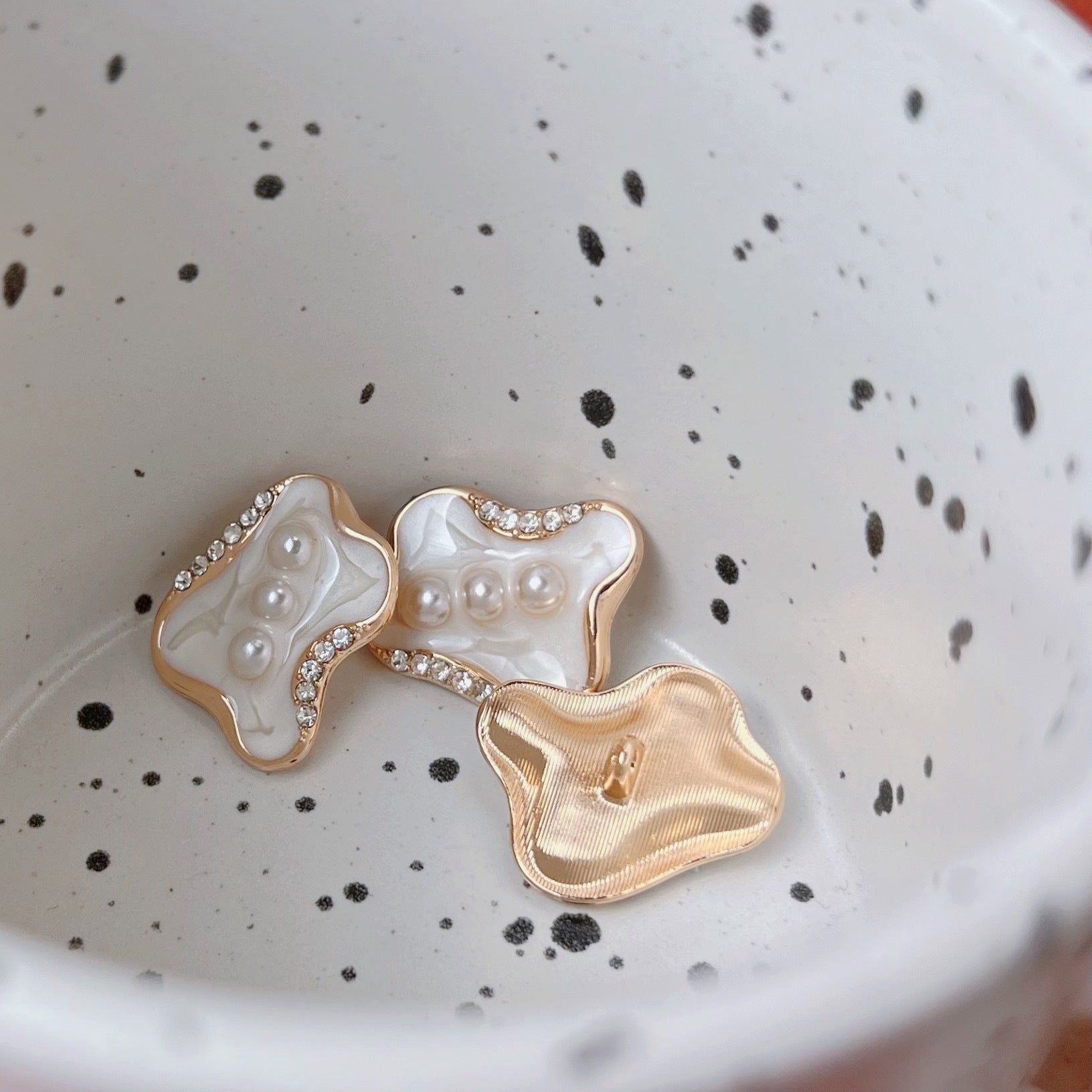 Mixed buttons: white faux-pearl flower design with rhinestone border and gold backing