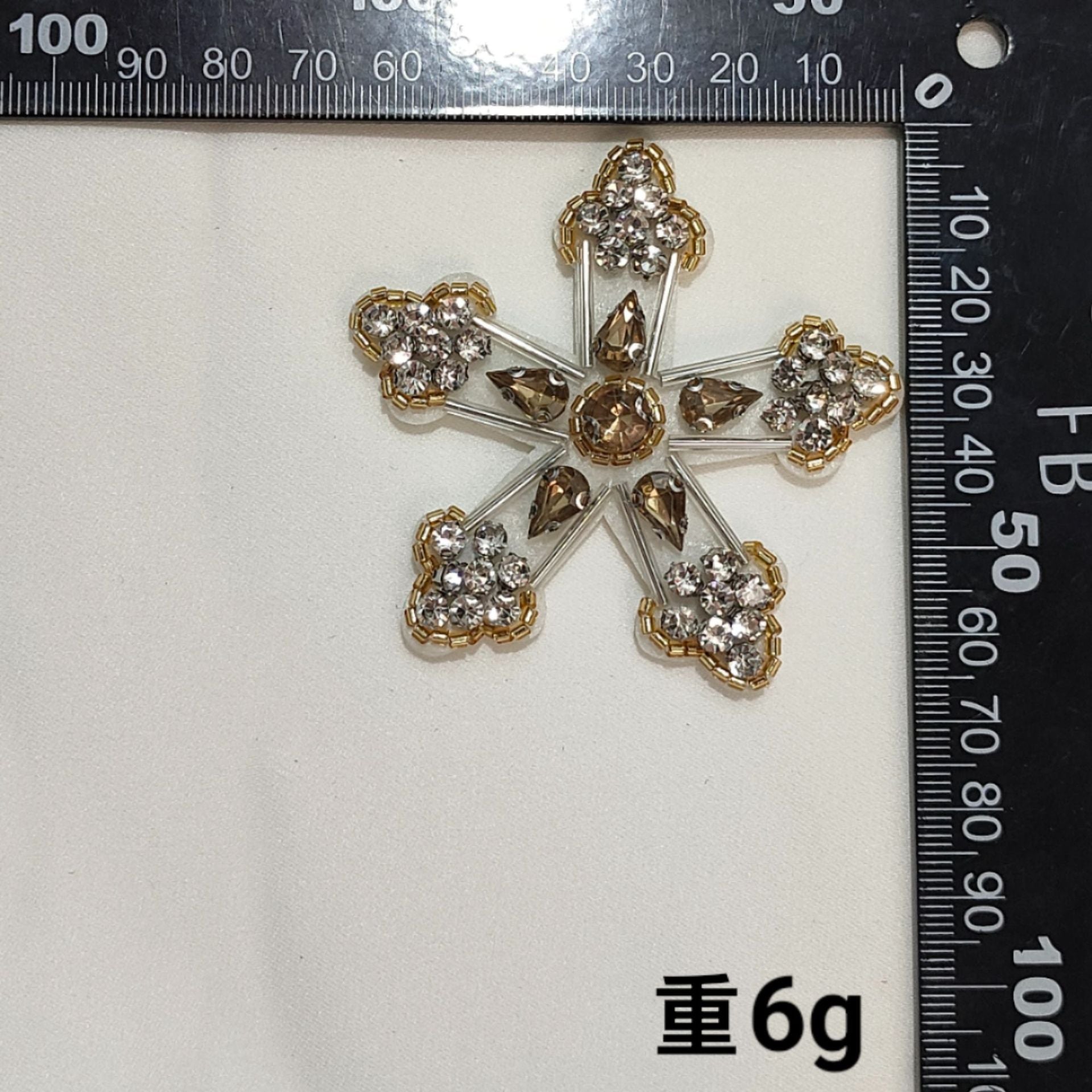 Gold-toned cross badge patch with clear rhinestones and ornate beaded detailing