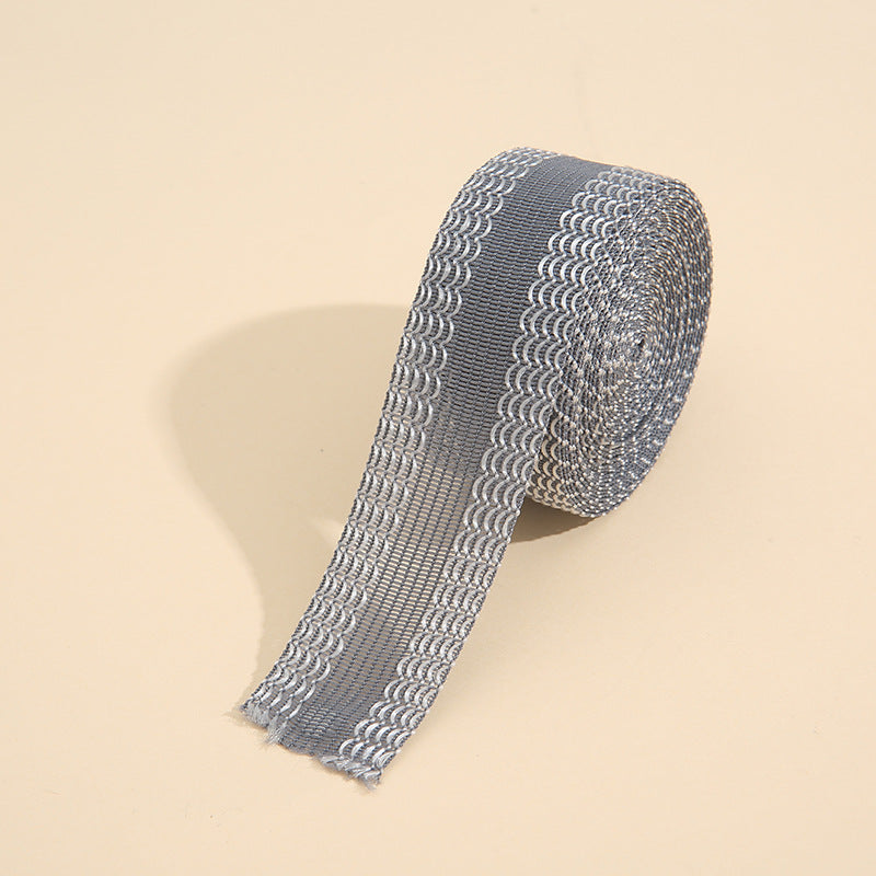 Grey iron-on instant hem tape roll with looped mesh pattern along the strip
