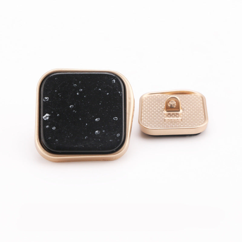 Black marble square shank button, gold metal frame; back view with mounting pin