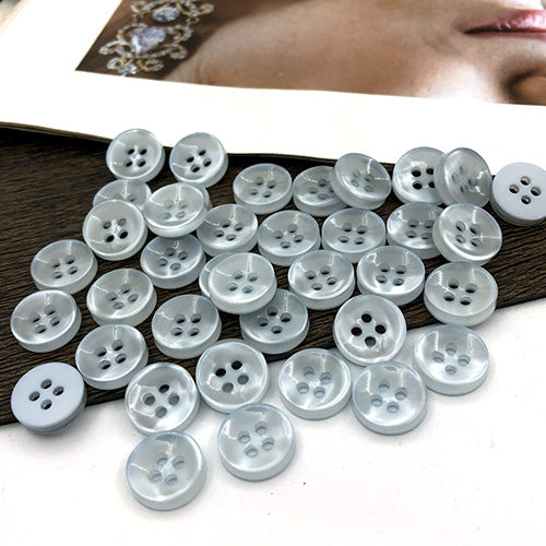 Pale blue round 4-hole shirt buttons, visible button fronts and holes
