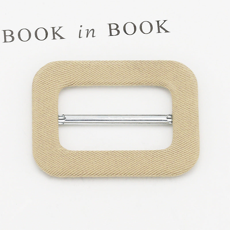 Fabric-covered D-ring buckle for belt adjustment, light brown fabric with silver metal bar