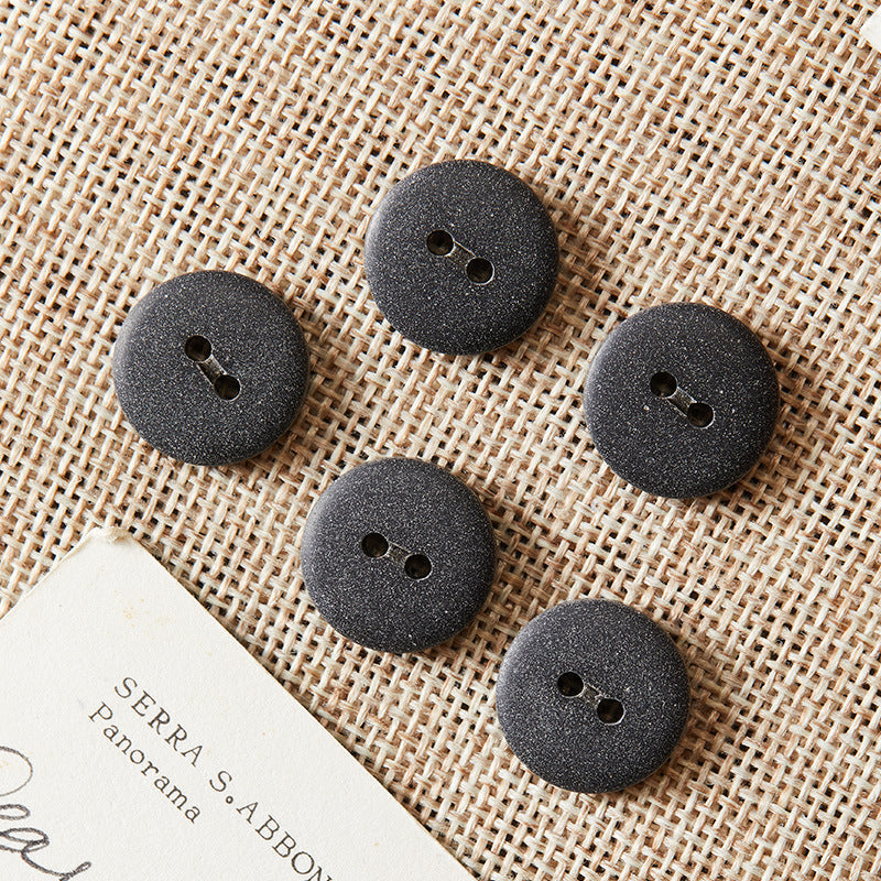 Round two-hole eco-resin buttons in black, dark speckled finish