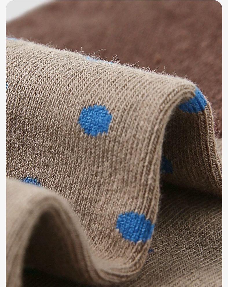 Beige knit crew sock with scattered blue polka dots and ribbed cuff