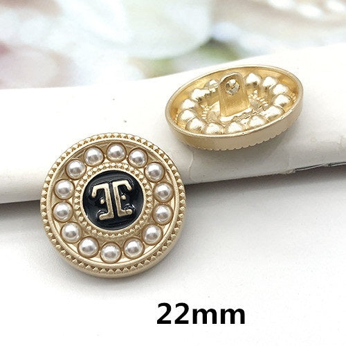 22mm gold round decorative button with pearl border and dark letter-style center