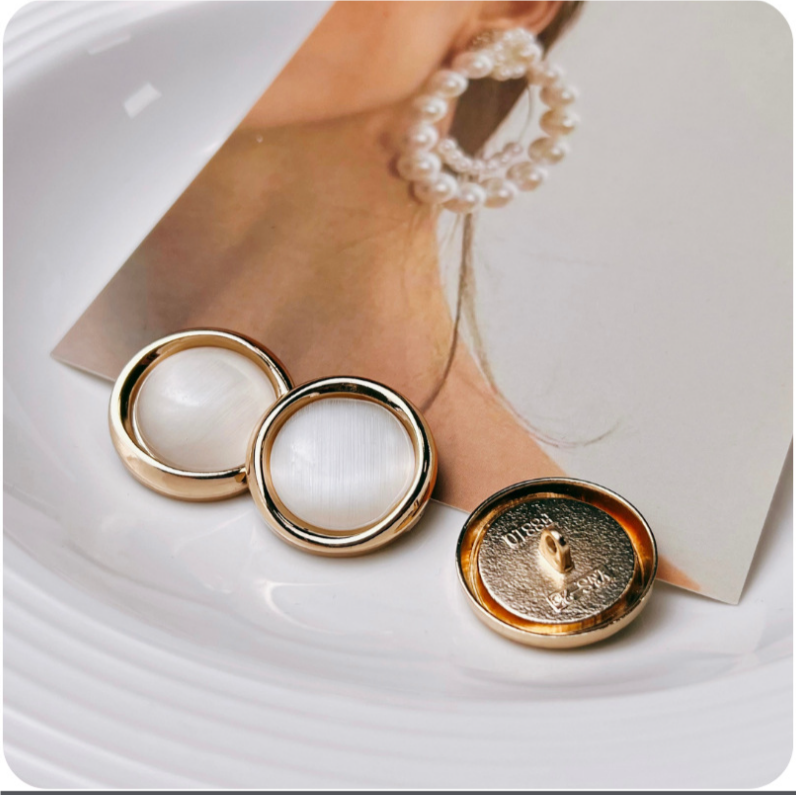 Pearly opalescent cat-eye button front and underside, gold metal setting