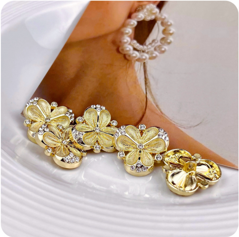 Gold three-petal flower metal shank buttons with rhinestone accents and studded petals