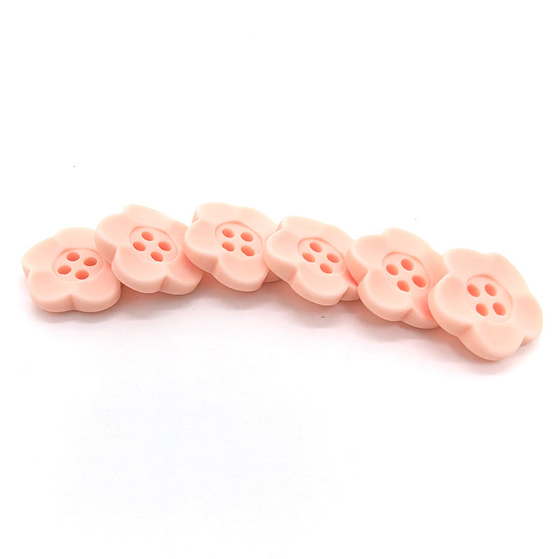 Pale pink four-hole flower buttons in a line, matte finish