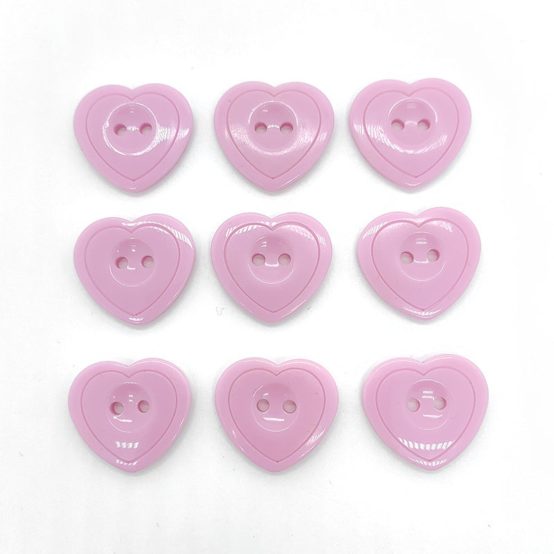 Glossier pink heart-shaped resin buttons with two-hole faces, set of fronts
