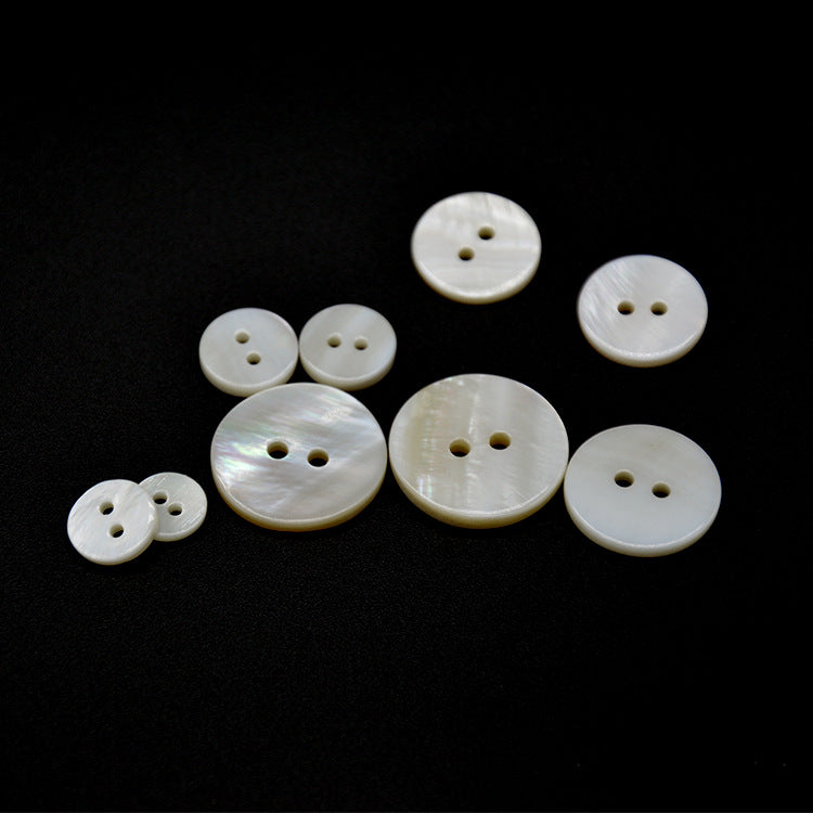Natural white shell two-hole flat buttons with pearlescent sheen, assorted sizes
