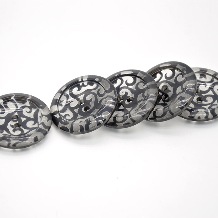 Mehrere 38mm runde transparente Resin-2-Lochknöpfe mit Schwarz-Grau Ornamenten.