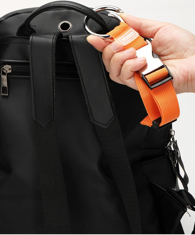 Orange luggage add-a-bag strap with ring hook attached to a black bag