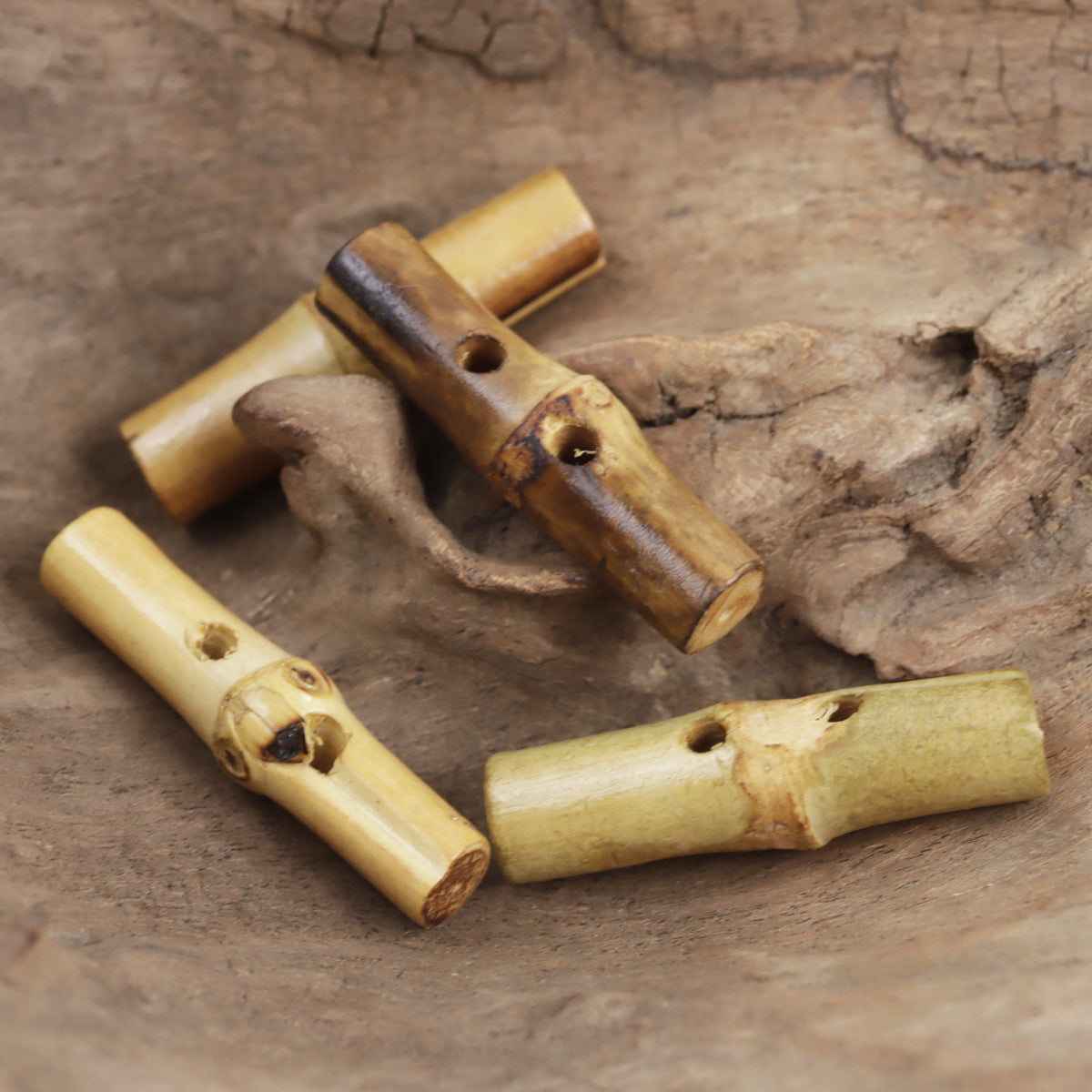 Set of irregular bamboo knot toggle buttons, light tan and dark brown tones, visible holes