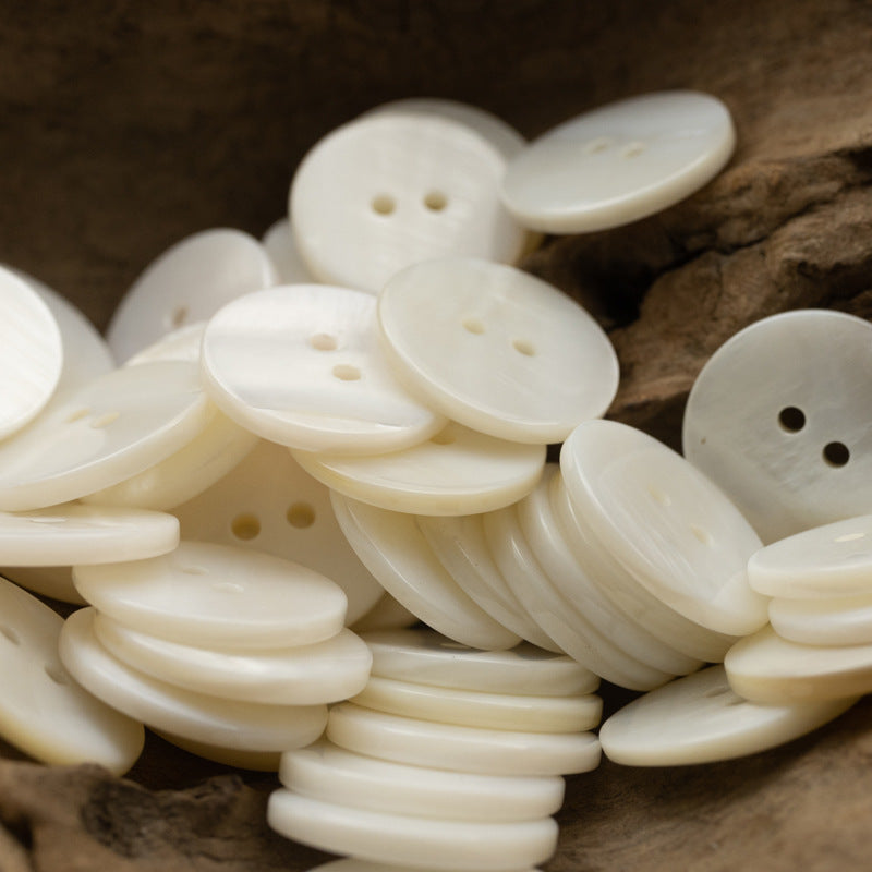 Assorted 2-hole flat shell buttons in white/cream, round, glossy, two-hole design