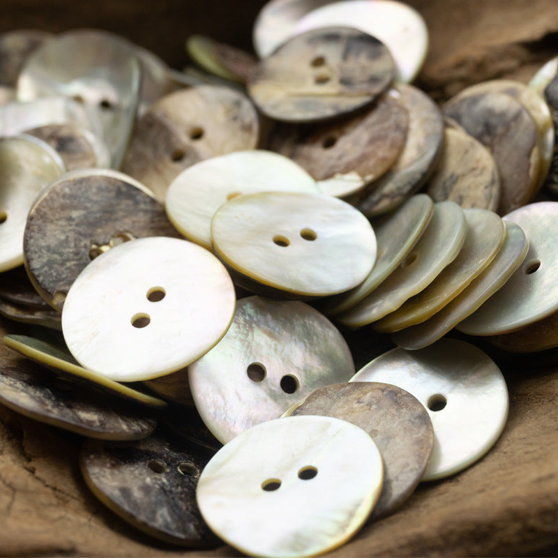 Assorted 2-hole flat shell buttons in mixed pearl colors and dark tones, round