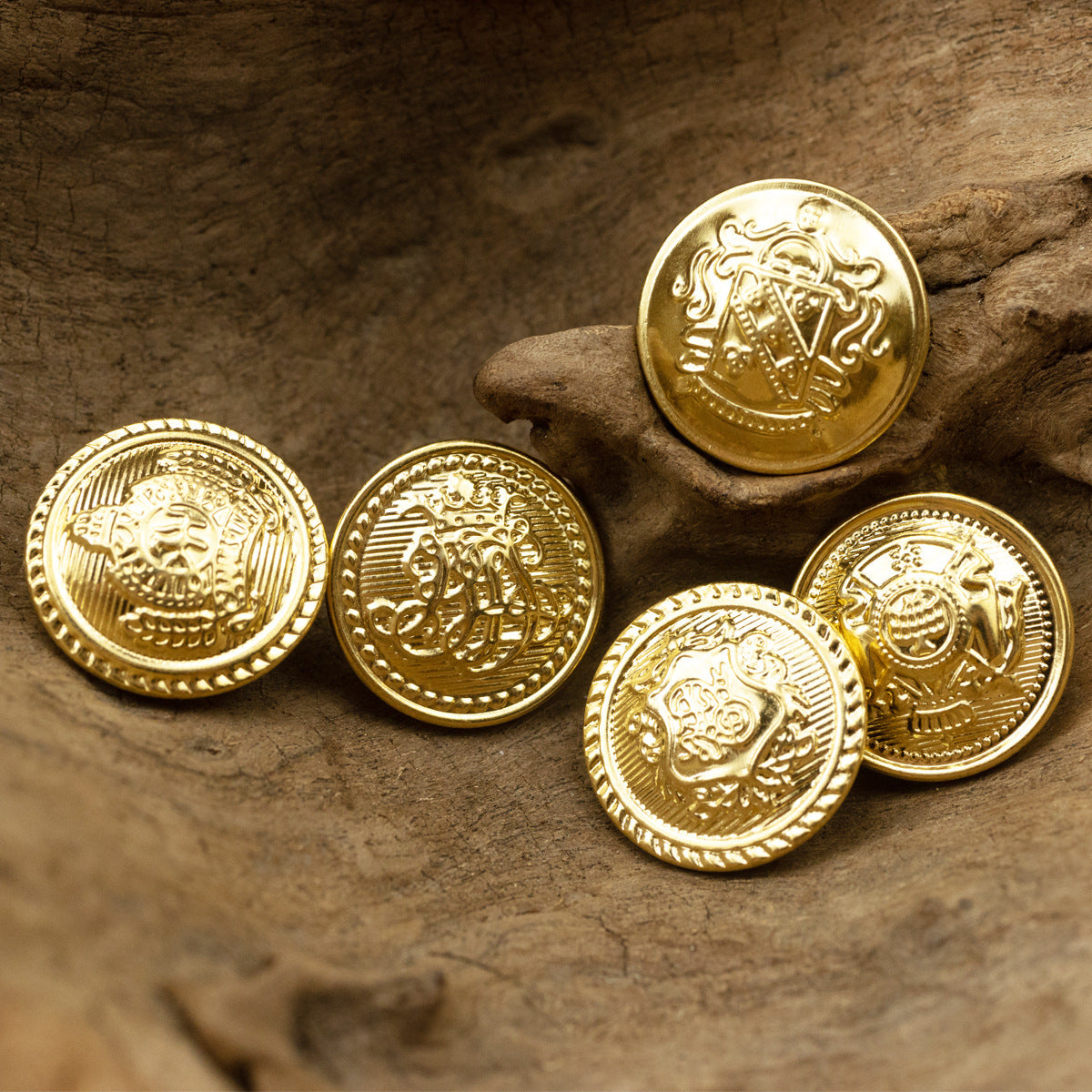 Gold metal shank button with crown emblem, front face and ridged border