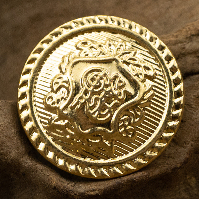 Gold metal shank button close-up front with flag emblem and patterned border