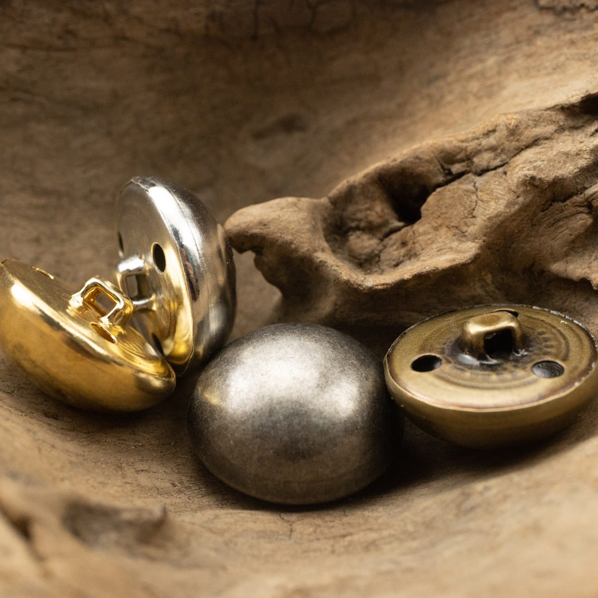 Metal shank button underside close-up, two round backs with holes and post